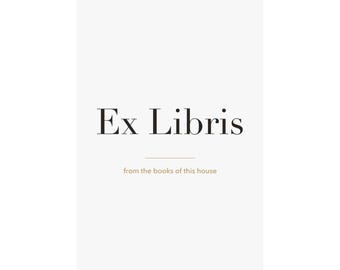 May include: A white rectangular poster hanging from two black metal clips. The text Ex Libris is printed in large black serif font, with the smaller text from the books of this house centred below it in a light brown sans-serif font.