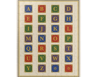May include: A rectangular jigsaw puzzle featuring a cream-coloured background with a grid of twenty-six colourful squares. Each square contains a gold letter from A to Z, with the final two squares displaying gold star and sun icons.