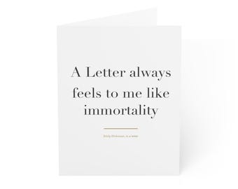 May include: A white greeting card featuring the black text A Letter always feels to me like immortality, with a thin horizontal brown line below and the smaller brown text Emily Dickinson, in a letter at the bottom centre.