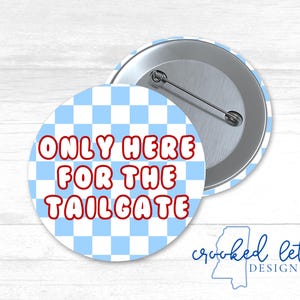 Puede incluir: Un botón a cuadros azules y blancos con el texto "ONLY HERE FOR THE TAILGATE" en letras rojas.