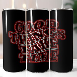 Könnte beinhalten: Drei schwarze Edelstahlbecher mit einer roten und grauen Grafik, auf der "GOOD THINGS TAKE TIME" steht.