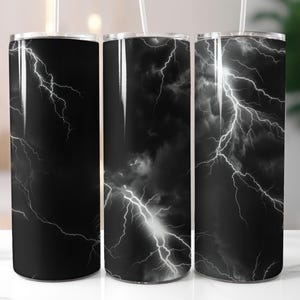 May include: Three stainless steel tumblers with a black and white lightning bolt pattern. The tumblers are all the same size and shape.