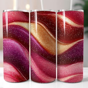 Könnte beinhalten: Drei Edelstahlbecher mit einem abstrakten Wirbelmuster in Rot, Gold und Rosa. Das Design hat einen Glitzer-Effekt.