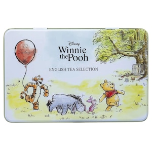 以下が含まれることがあります： くまのプーさんのキャラクターが描かれた長方形の缶。缶は、ティガー、イーヨー、ピグレット、くまのプーさんのイラストが描かれた水色の背景です。缶には「Disney Winnie the Pooh English Tea Selection」と「72 Teabags」と書かれています。