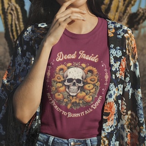 May include: A maroon t-shirt with a skull and sunflowers graphic. The text on the shirt reads "Dead Inside But Ready To Burn It All Down".