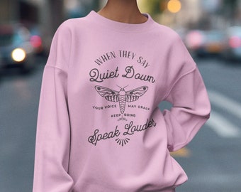 May include: Pink sweatshirt with a black moth graphic and the text "When they say Quiet Down your voice may crack keep going Speak Louder".