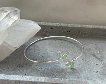 Brazalete de plata con motivo de hoja verde: delicado y natural.