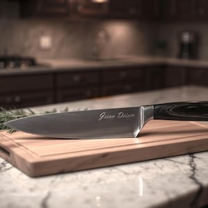 Puede incluir: Un cuchillo de chef de acero inoxidable con mango de madera oscura descansa sobre una tabla de cortar de madera. La hoja tiene grabado el nombre "Jason Deines". Una ramita de romero est&aacute; junto a la tabla, lo que sugiere uso culinario.