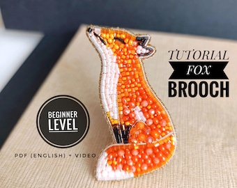 Könnte beinhalten: Ein fuchs-förmiger Broschenanhänger aus orangefarbenen, weißen und schwarzen Perlen. Die Brosche ist mit kleinen Perlen gefertigt und hat ein detailliertes Design. Der Text "Tutorial Fox Brooch" ist über der Brosche und "Beginner Level" darunter zu sehen.