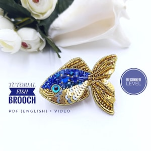 May include: A blue and gold beaded fish brooch with an evil eye detail. The brooch is on a white background with flowers. The text "TUTORIAL FISH BROOCH" and "PDF (ENGLISH) + VIDEO" is below the brooch. The text "BEGINNER LEVEL" is in a purple circle in the upper right corner of the image.