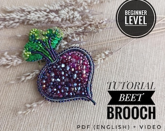 Könnte beinhalten: Eine perlenbesetzte Rote-Bete-Brosche mit dunkelvioletten und roten facettierten Kristallen für die Wurzel und leuchtend grünen Pailletten für die Blätter. Das Bild enthält den Text BEGINNER LEVEL, TUTORIAL BEET BROOCH und PDF (ENGLISH) + VIDEO.