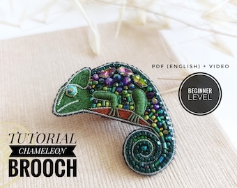 Könnte beinhalten: Handgefertigte Brosche in Form eines Chamäleons mit grünen, blauen und violetten Perlen. Die Brosche trägt den Text "Tutorial Chameleon Brooch" und "Beginner Level". Das Tutorial ist als PDF (Englisch) + Video verfügbar.