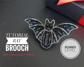 Könnte beinhalten: Eine schwarze Fledermaus-Brosche mit aufwendigen Perlen- und Paillettenverzierungen. Die Brosche hat eine silberne Drahtkontur und blaue Pailletten-Akzente. Der Text auf dem Bild lautet "Tutorial Bat Brooch" und "Beginner Level".