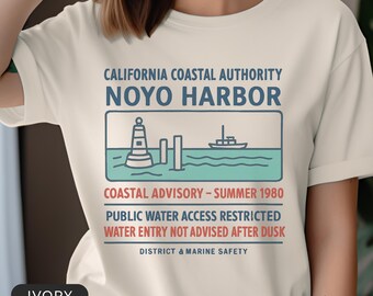 Camiseta de aviso sobre el agua del puerto de Noyo, camiseta vintage de advertencia costera, camiseta inspirada en películas de terror de culto, camiseta gráfica retro de criaturas.