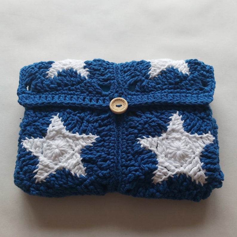 May include: Blue crocheted clutch with white star designs and a wooden button that says "Handmade with Love".