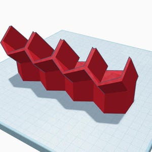May include: A red, geometric, modular storage unit composed of connected hexagonal cells. The unit is displayed on a white surface with a grid pattern. The design features sharp angles and a modern aesthetic, suitable for organizing small items.