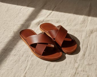 May include: A white ceramic mug with a black handle and the text "But First, Coffee" in a black, handwritten-style font. The mug is on a white surface.