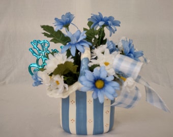 Boy Baby Shower Centerpiece with blue and white daisies and a blue gingham bow in a Andrea West  ceramic basket. "Its A Boy" blue sign.
