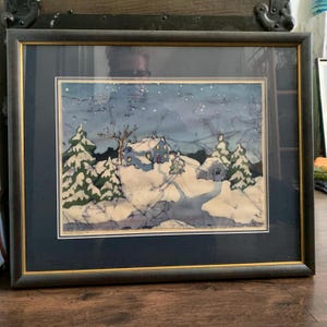 May include: A framed watercolor painting depicting a snowy winter scene with a small house and trees under a starry night sky.