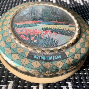 Vintage/Antique BREDA-HOLLAND Round 4 3/4”x 4 3/4” Metal Tin/Canister w/Images of Flowers from Kwatta; Rare Advertising Tin Made In Holland