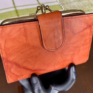 Portefeuille MUNDI « VRAI CUIR » en cuir véritable souple 4 1/2 po. x 5 3/8 po. marbré Cognac Kiss/Ball Lock avec divers compartiments et insert pour carte, vers les années 1970