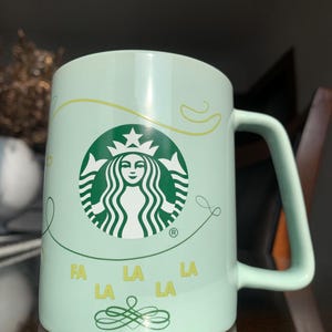 Unused 11 fl oz Collectible 4”x 4 1/2” STARBUCKS COFFEE “Fa la la la” Limited Edition Ceramic Holiday Mug w/Wrap Around Design; Xmas Gift