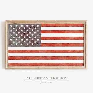 Könnte beinhalten: Ein gerahmter Druck einer amerikanischen Flagge im Vintage-Stil mit Aquarell-Effekt. Die Flagge ist rot, weiß und blau mit einem abgenutzten Look. Der Rahmen ist in hellem Holz gehalten.