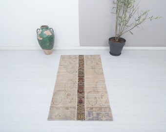 May include: A beige runner rug with a patterned border in shades of red, yellow, and blue. The rug has a distressed, vintage look.