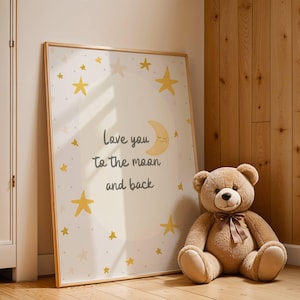 May include: A framed print with the text "Love you to the moon and back" and a crescent moon and stars design. A large brown teddy bear with a brown ribbon sits next to the framed print. The print is in a light wood frame.