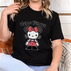 May include: Black t-shirt with a white Hello Disney graphic and a cartoon image of a red and white polka dot Hello Kitty character with a red bow.