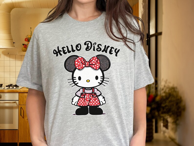 May include: Gray t-shirt with a Hello Disney graphic featuring a cartoon character with red polka dot overalls and a red bow.