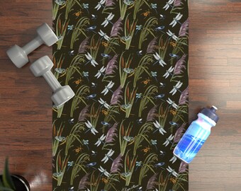 May include: A dark green yoga mat with a repeating pattern of dragonflies, cattails, and grasses. The mat has a subtle sheen and a textured surface.