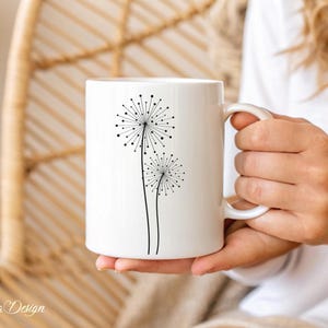 May include: White ceramic mug with a black silhouette of two dandelions on the front.