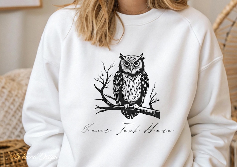 Puede incluir: Sudadera blanca con una ilustraci&oacute;n en blanco y negro de un b&uacute;ho posado en una rama. El texto "Your Text Here" est&aacute; impreso debajo del b&uacute;ho.