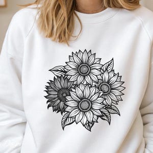 Puede incluir: Una sudadera blanca con un gr&aacute;fico en blanco y negro de un ramo de girasoles.