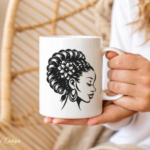 May include: White ceramic mug with a black and white illustration of a woman with a flower in her hair. The woman is looking to the right.