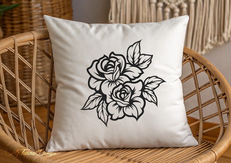 May include: A white pillow with a black silhouette of two roses and leaves. The roses are in full bloom and have a classic design.