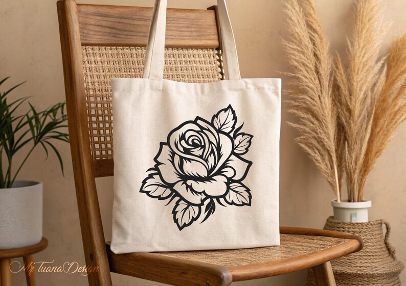 May include: A white canvas tote bag with a black silhouette of a rose printed on the front.