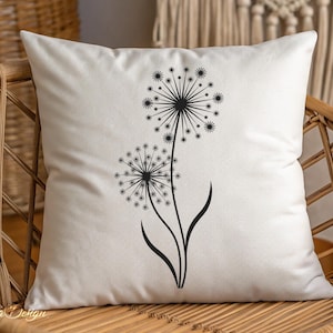 May include: A white pillow with a black silhouette of two dandelions with their seeds blowing in the wind.