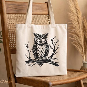 Puede incluir: Una bolsa de lona blanca con una ilustraci&oacute;n en blanco y negro de un b&uacute;ho posado en una rama. El b&uacute;ho tiene ojos grandes y redondos y un patr&oacute;n de plumas detallado.