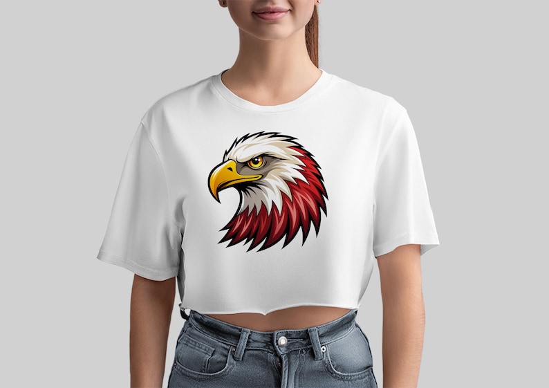 May include: White cropped t-shirt with a cartoon image of an eagle's head with red, white, and yellow feathers.