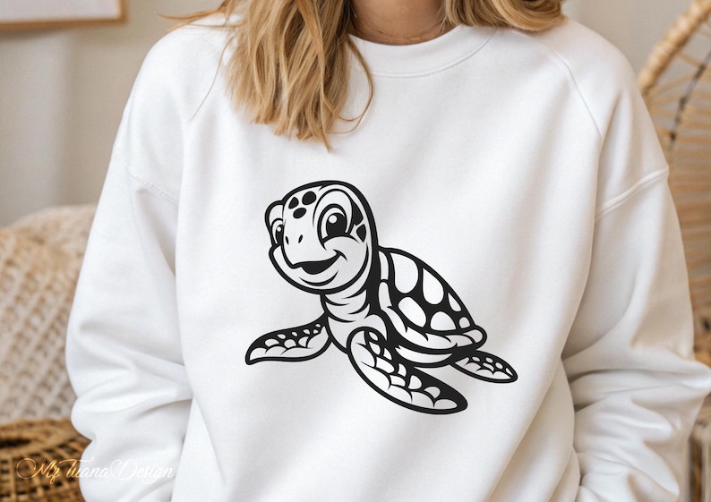 Pu&ograve; includere: Felpa bianca con una grafica di tartaruga marina a cartoni animati in bianco e nero. La tartaruga sorride e ha un guscio con un motivo a pois.