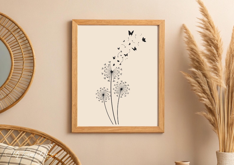May include: A black and white print of three dandelions with butterflies flying away from them. The print is framed in a light wood frame.