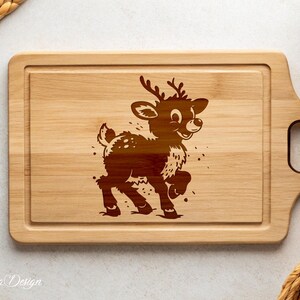 May include: A wooden cutting board with a brown reindeer design engraved on the surface. The board has a handle on the side.
