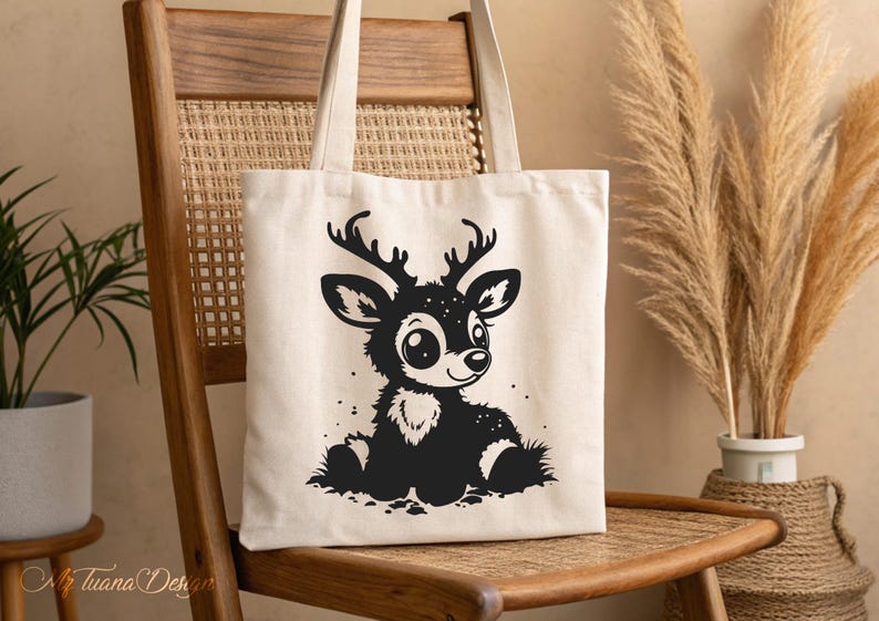 May include: A white canvas tote bag with a black and white illustration of a cartoon deer with big eyes. The deer is sitting on a white background.