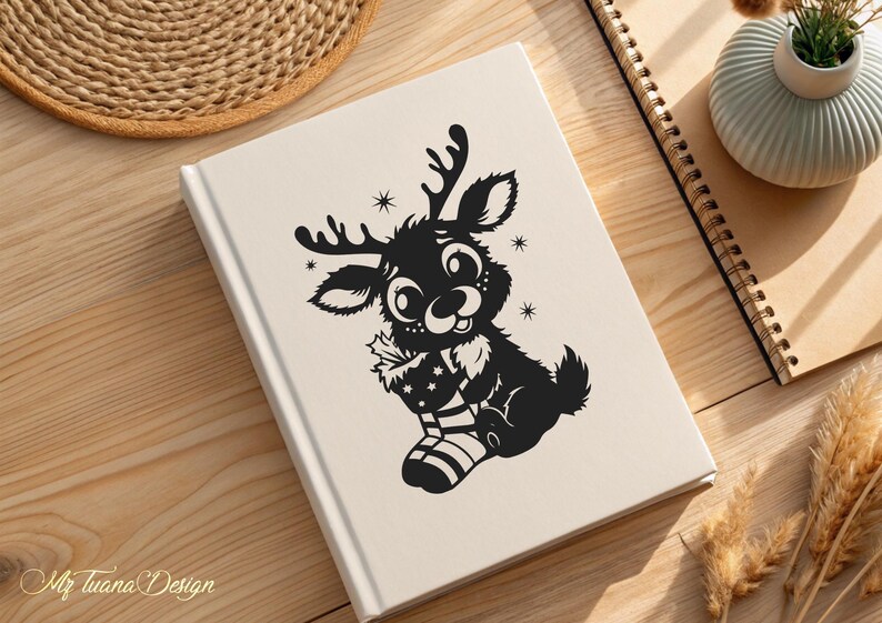 May include: A black and white illustration of a reindeer holding a Christmas stocking. The reindeer has large eyes and a smiling face.
