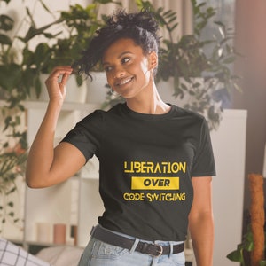 May include: A black t-shirt with the text "LIBERATION OVER CODE SWITCHING" in yellow.