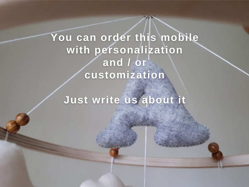 May include: A baby mobile with a wooden hoop and hanging felt shapes. A large gray felt letter "A" is suspended in the center. The text on the image says, "You can order this mobile with personalization and/or customization. Just write us about it."