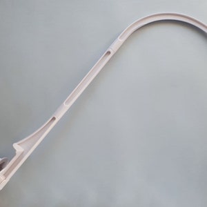 May include: A light pink baby mobile arm with a curved top and a screw-on base. The arm is designed to attach to a crib and hold a mobile. The arm is made of plastic and has a simple, functional design.