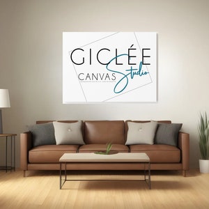 May include: A brown leather sofa with three pillows, a coffee table, a lamp, and a plant in a white pot. A white canvas print with the text "GICLEE CANVAS Studio" in black and blue is hanging on the wall.